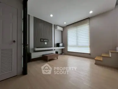 Modern minimalist living room with wooden flooring and natural light