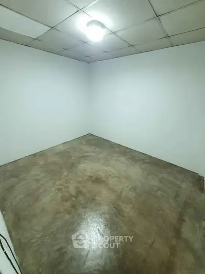 Spacious empty room with polished concrete floor and bright lighting.