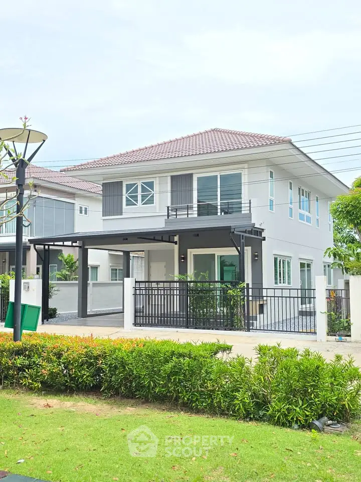 Modern two-story house with landscaped garden and spacious driveway in a serene neighborhood.