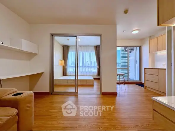Spacious modern apartment with open layout and wooden flooring, featuring a cozy living area and bright bedroom.
