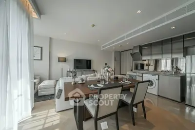Modern open-plan living room and kitchen with elegant dining area and natural light
