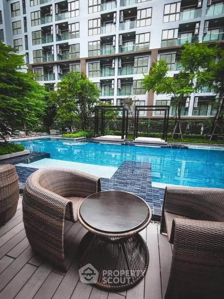Luxurious apartment complex with inviting pool and stylish outdoor seating area.
