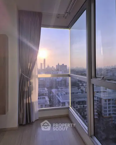 Stunning corner unit with panoramic city view and floor-to-ceiling windows at sunset.