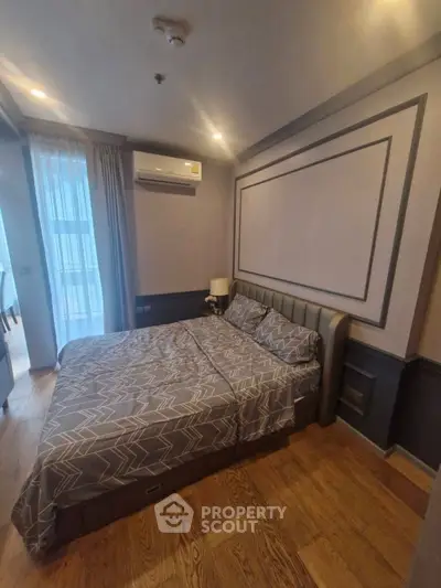 Modern bedroom with stylish decor and wooden flooring in a cozy apartment.