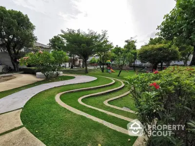 Beautiful landscaped garden with winding pathways and lush greenery in a serene residential area.