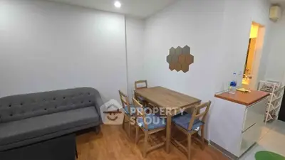 Cozy living room with modern furniture and dining area, perfect for small gatherings.
