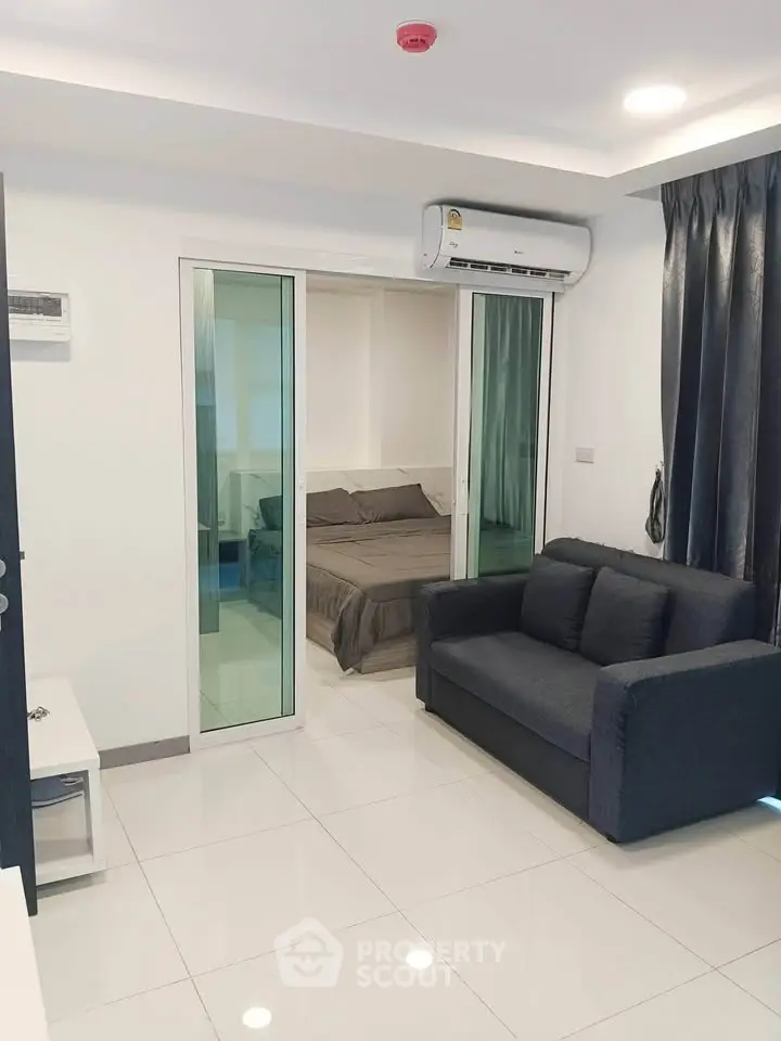 Modern apartment interior with sleek living room and cozy bedroom, featuring air conditioning and stylish decor.