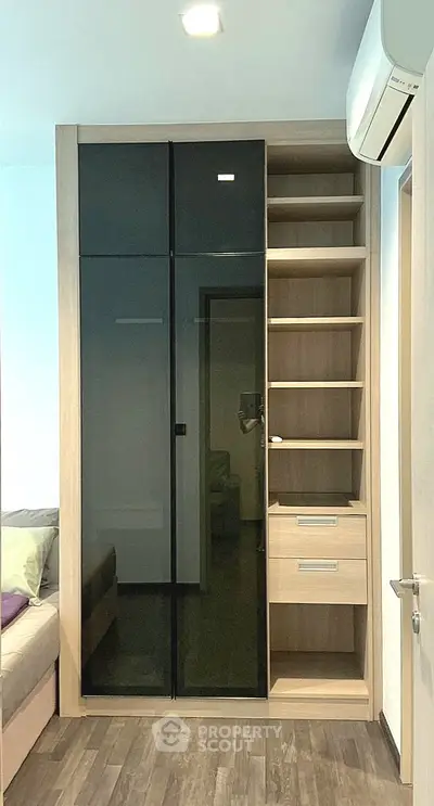 Modern bedroom with sleek built-in wardrobe and air conditioning unit, perfect for stylish urban living.