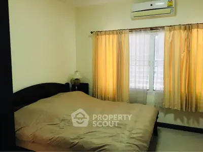 Cozy bedroom with natural light and air conditioning, perfect for restful nights.