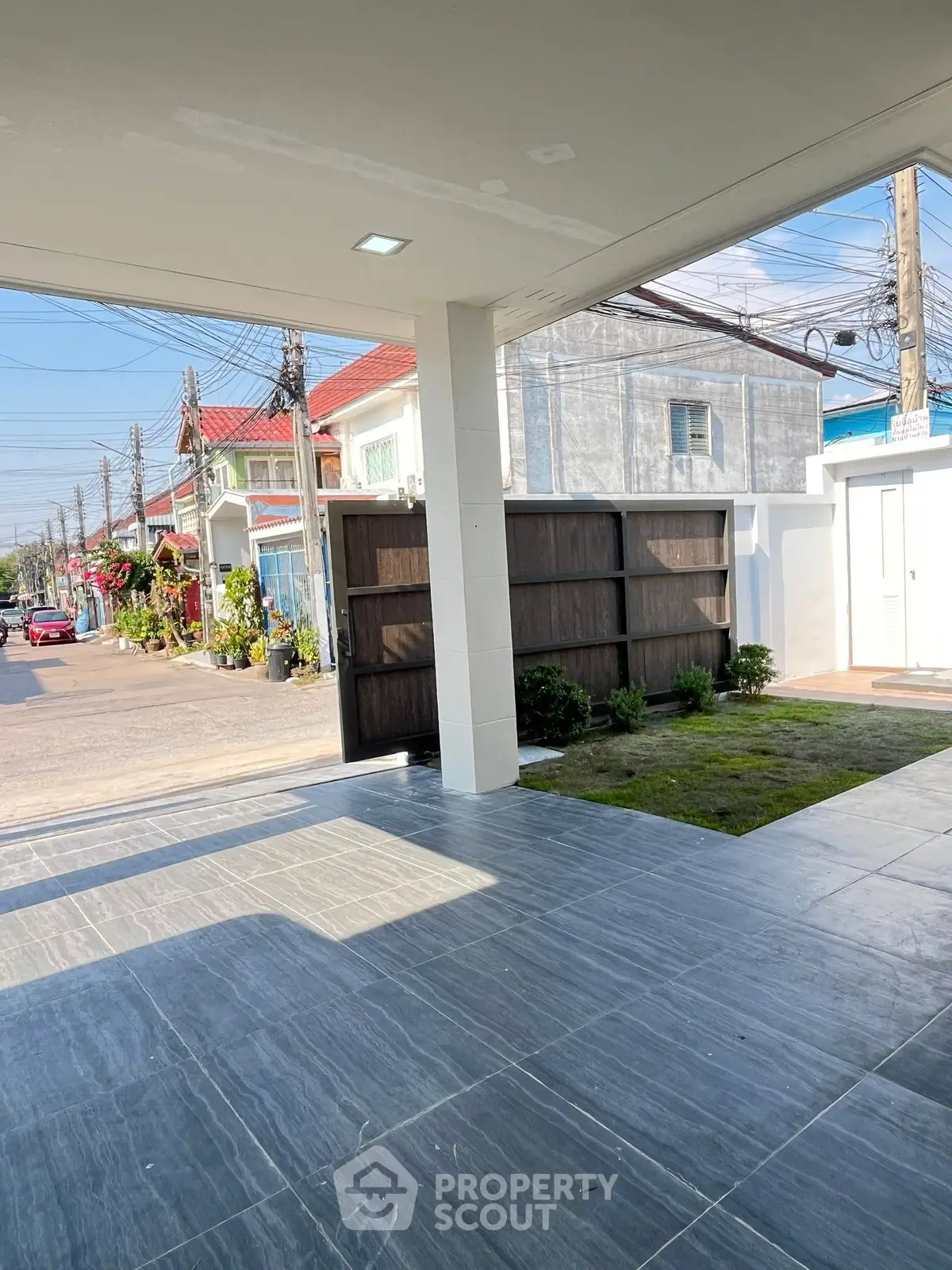 Spacious modern carport with sleek tiled flooring and street view in a suburban neighborhood.