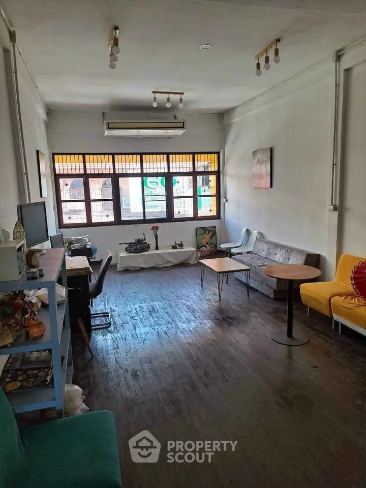 Spacious living room with eclectic furniture and large windows