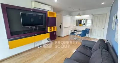 Modern living room with stylish furniture and wall-mounted TV in a cozy apartment.