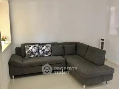 Modern living room with stylish gray sectional sofa and minimalist decor