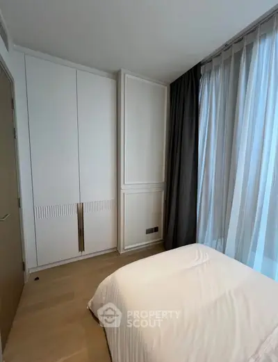 Modern bedroom with sleek wardrobe and floor-to-ceiling curtains