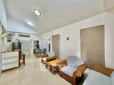 Spacious living room with high ceiling and cozy wicker furniture, perfect for relaxation and entertaining.