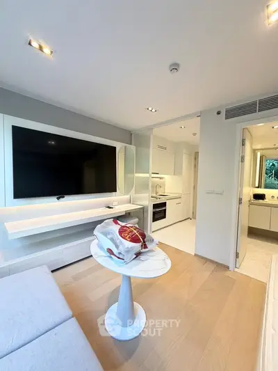 Modern living room with sleek TV setup and open kitchen layout