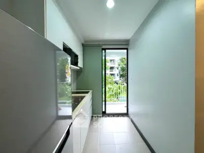 Modern kitchen with sleek design and balcony view in a stylish apartment.