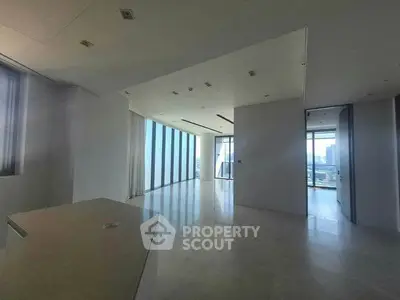 Spacious modern apartment with floor-to-ceiling windows and city view, perfect for luxury living.