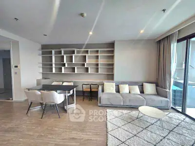 Spacious modern living room with stylish shelving and large windows for natural light.
