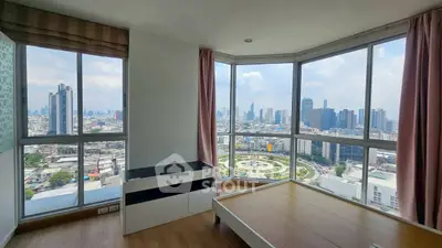 Stunning city view from modern high-rise bedroom with large windows and wooden flooring.