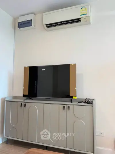 Modern living room with sleek TV cabinet and air conditioning unit, perfect for comfortable living.