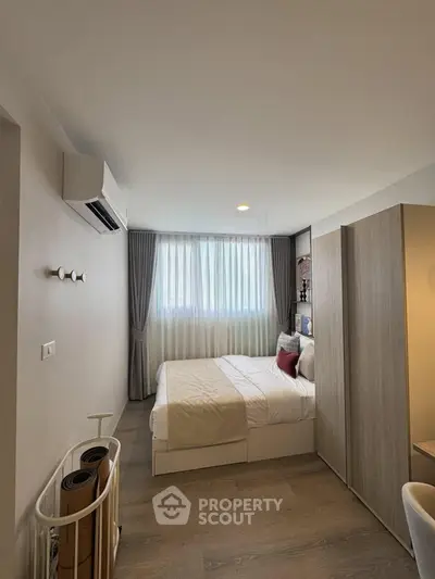 Cozy bedroom with modern decor and natural light, featuring a comfortable bed and stylish furnishings.