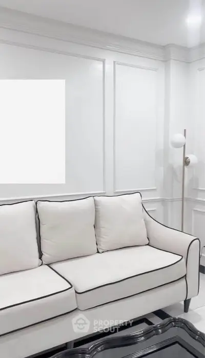 Elegant living room with white sofa and modern floor lamp in a stylish interior.