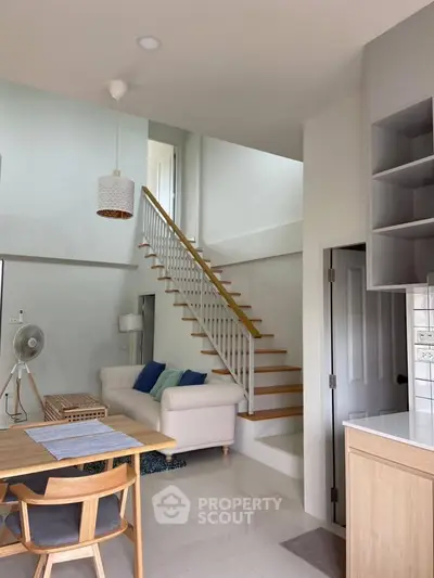 Modern living room with staircase and stylish decor in a bright, open space