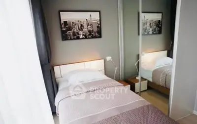 Cozy bedroom with stylish decor and mirrored wardrobe in modern apartment.