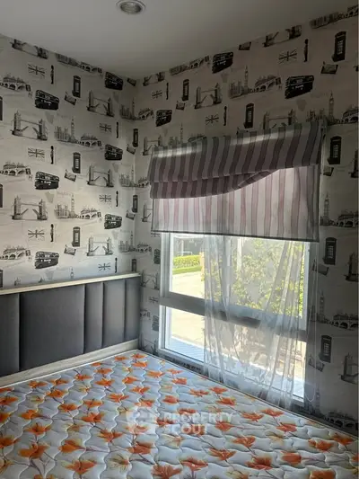 Cozy bedroom with stylish wallpaper and large window for natural light.