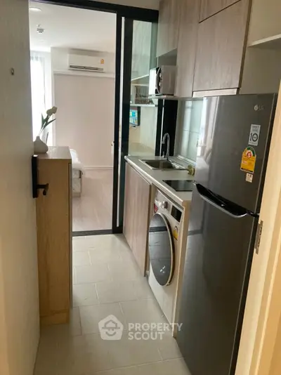 Modern compact kitchen with sleek appliances and open layout in a stylish apartment.