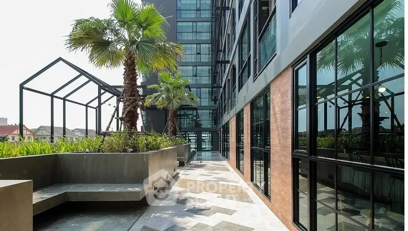 Modern building exterior with lush garden and sleek design elements.