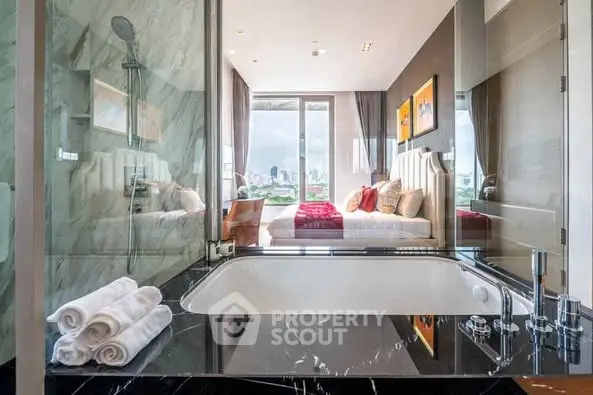 Luxurious bedroom with ensuite bathroom featuring a marble bathtub and city view.