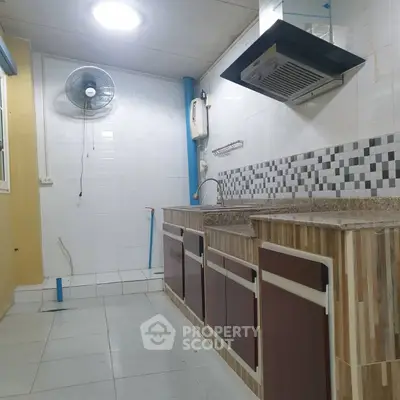 Spacious kitchen with modern backsplash and ventilation system, ideal for culinary enthusiasts.