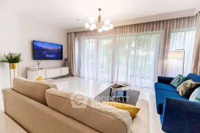 Spacious and elegant living room with modern decor and large windows.