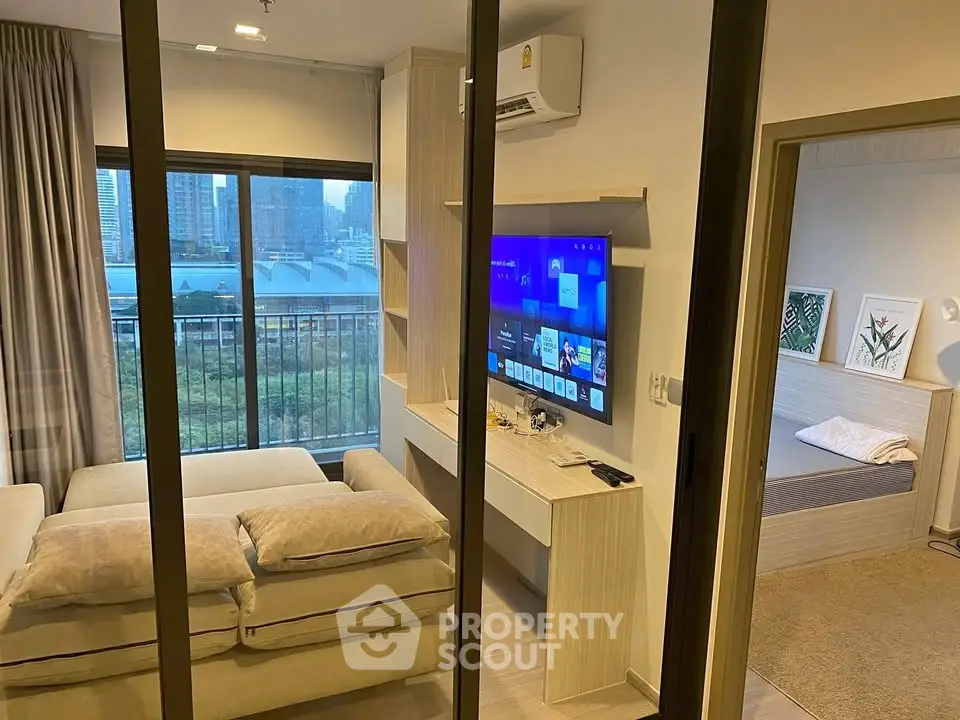 Modern living room with city view, featuring a cozy sofa and wall-mounted TV, perfect for urban living.