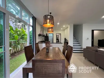 Modern open-plan dining area with garden view and stylish lighting