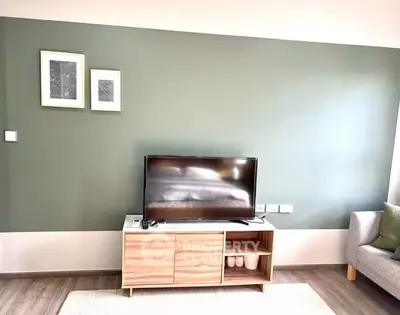 Modern living room with stylish TV stand and green accent wall
