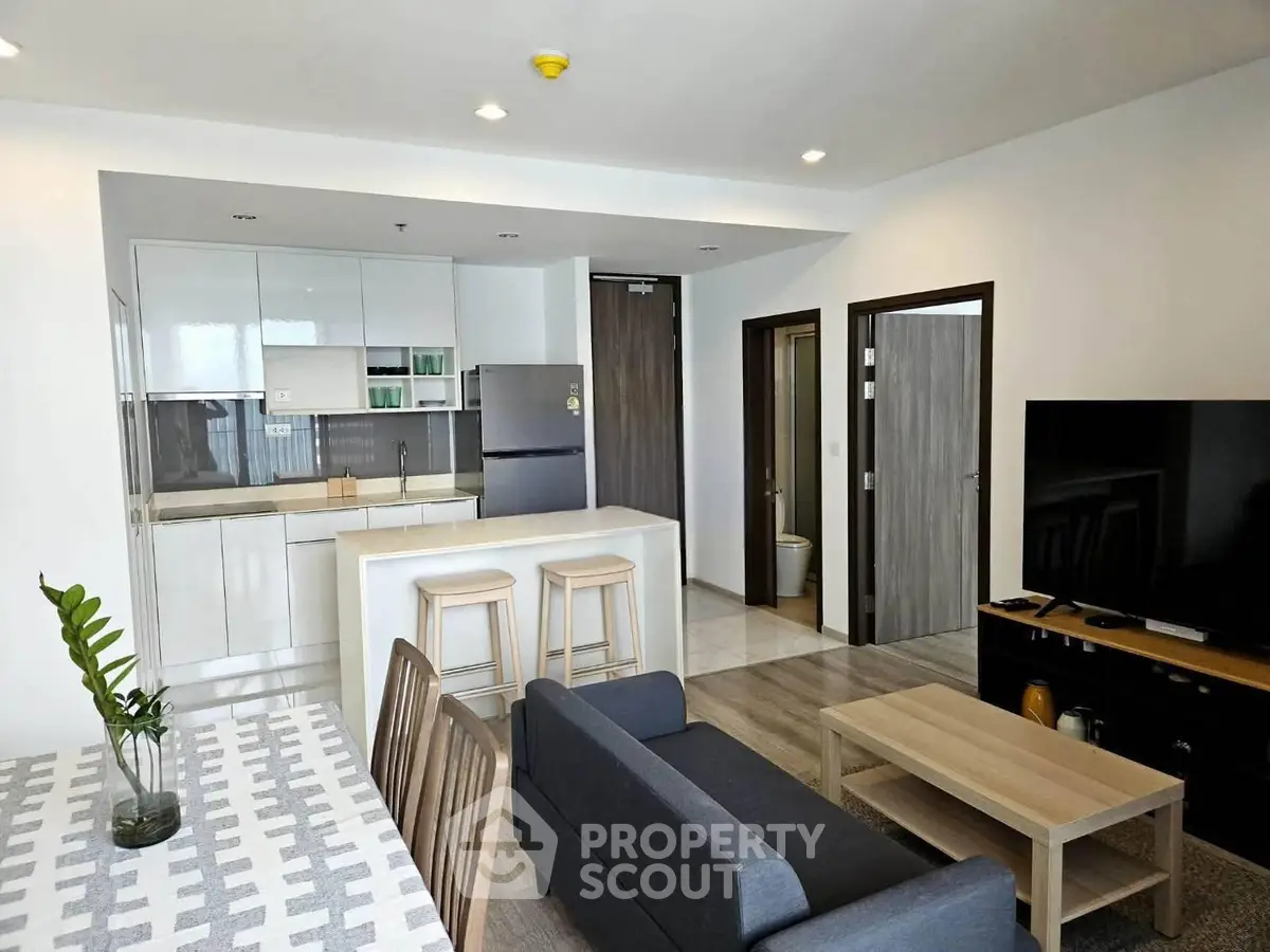 Modern open-plan living room with sleek kitchen and stylish furnishings