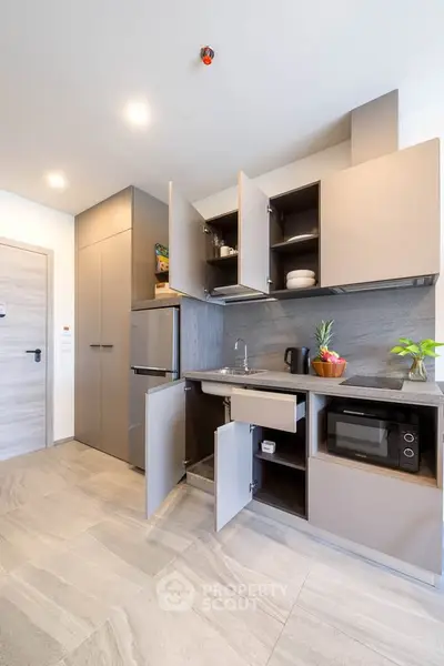 Modern kitchen with open cabinets and sleek appliances in a stylish apartment.