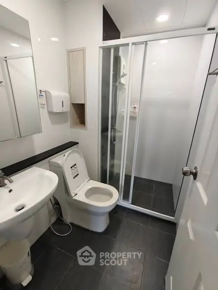 Modern bathroom with sleek shower and contemporary fixtures in a stylish real estate property.