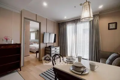 Chic modern living room with dining area and bedroom view, featuring elegant decor and natural light.