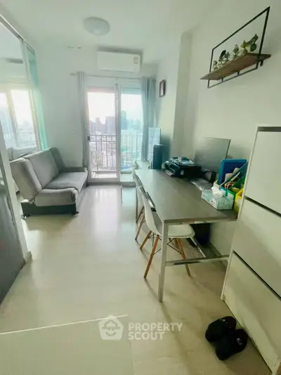 Modern apartment with compact living area and city view balcony, ideal for urban living.