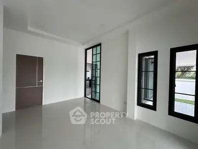 Spacious modern room with large windows and sleek tile flooring