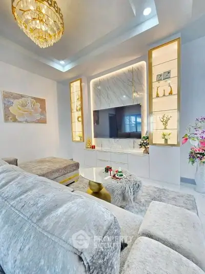 Luxurious living room with plush seating, elegant chandelier, and modern decor