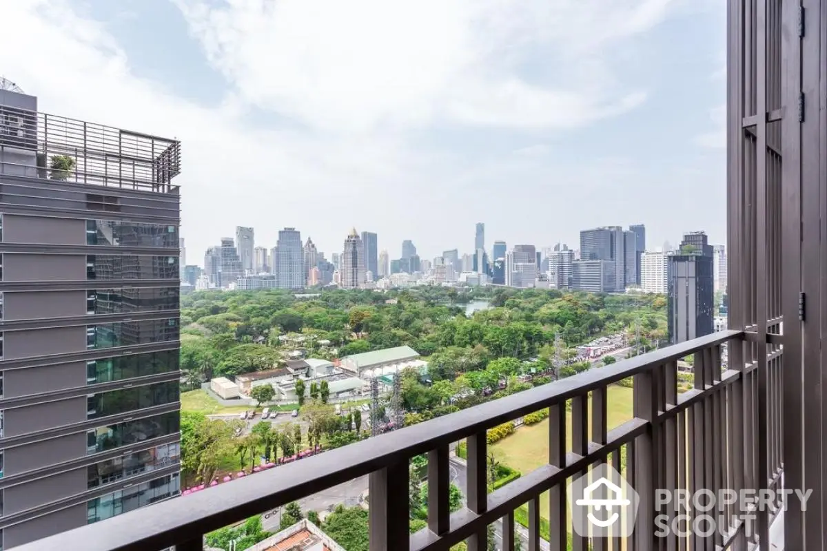 Stunning cityscape view from a high-rise balcony overlooking lush green park and skyline.