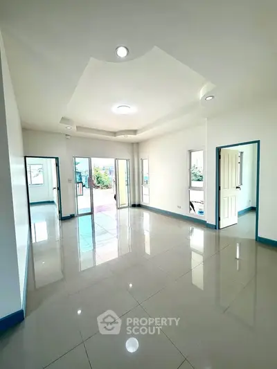 Spacious living room with glossy tiled floors and abundant natural light