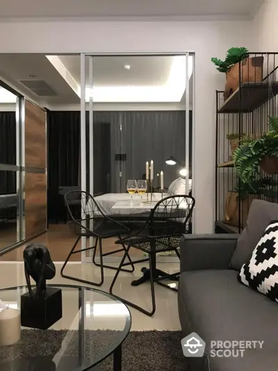 Chic modern living space with sleek furniture and stylish decor, featuring a cozy sofa, glass coffee table, and an inviting dining area with elegant table setting.