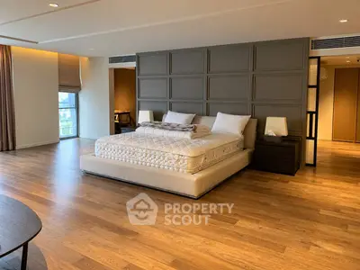 Luxurious bedroom with elegant wood flooring and modern decor in a spacious apartment.
