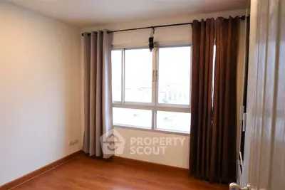 Cozy bedroom with large window and elegant curtains, perfect for natural light lovers.